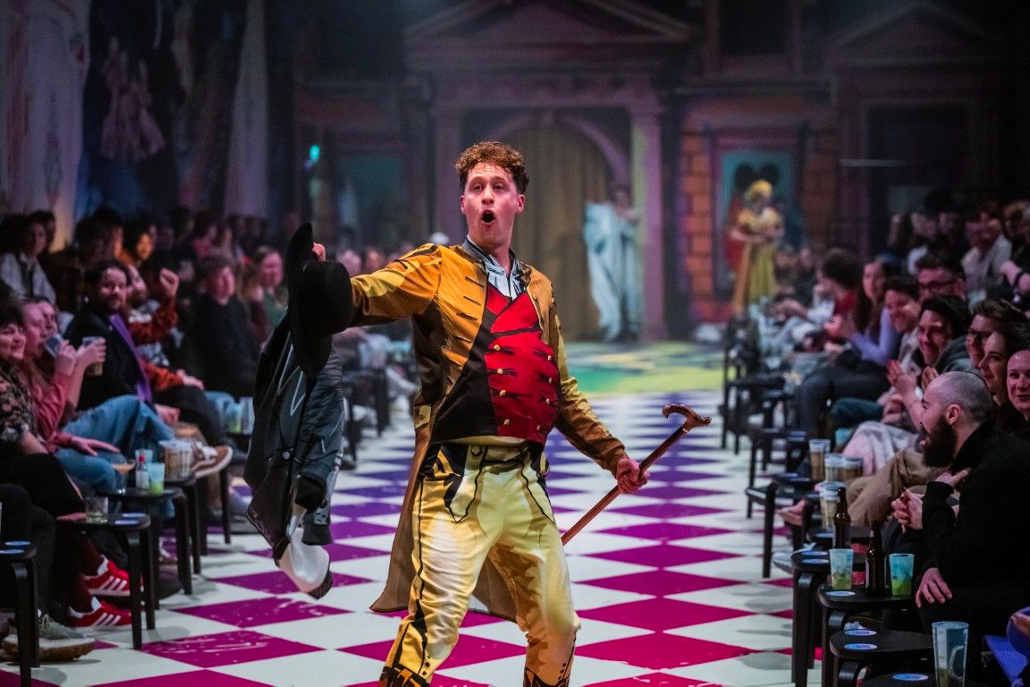 Andrew Macmillan commands attention in an elaborate soldier-style costume, dramatically brandishing a hat and cane to cheers and laughter from the packed audience.