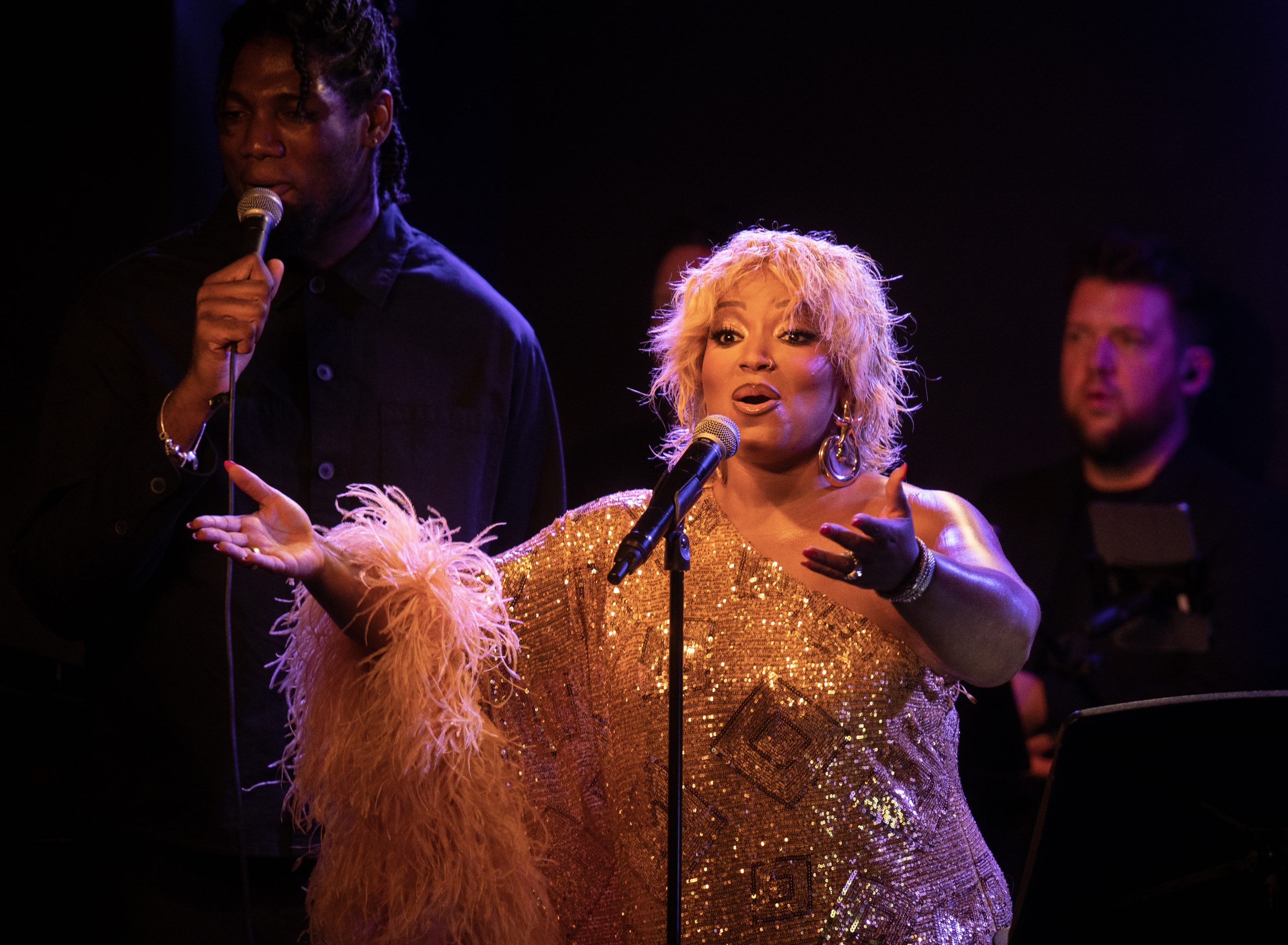Marisha Wallace singing with her palm raised at Ronnie Scott’s