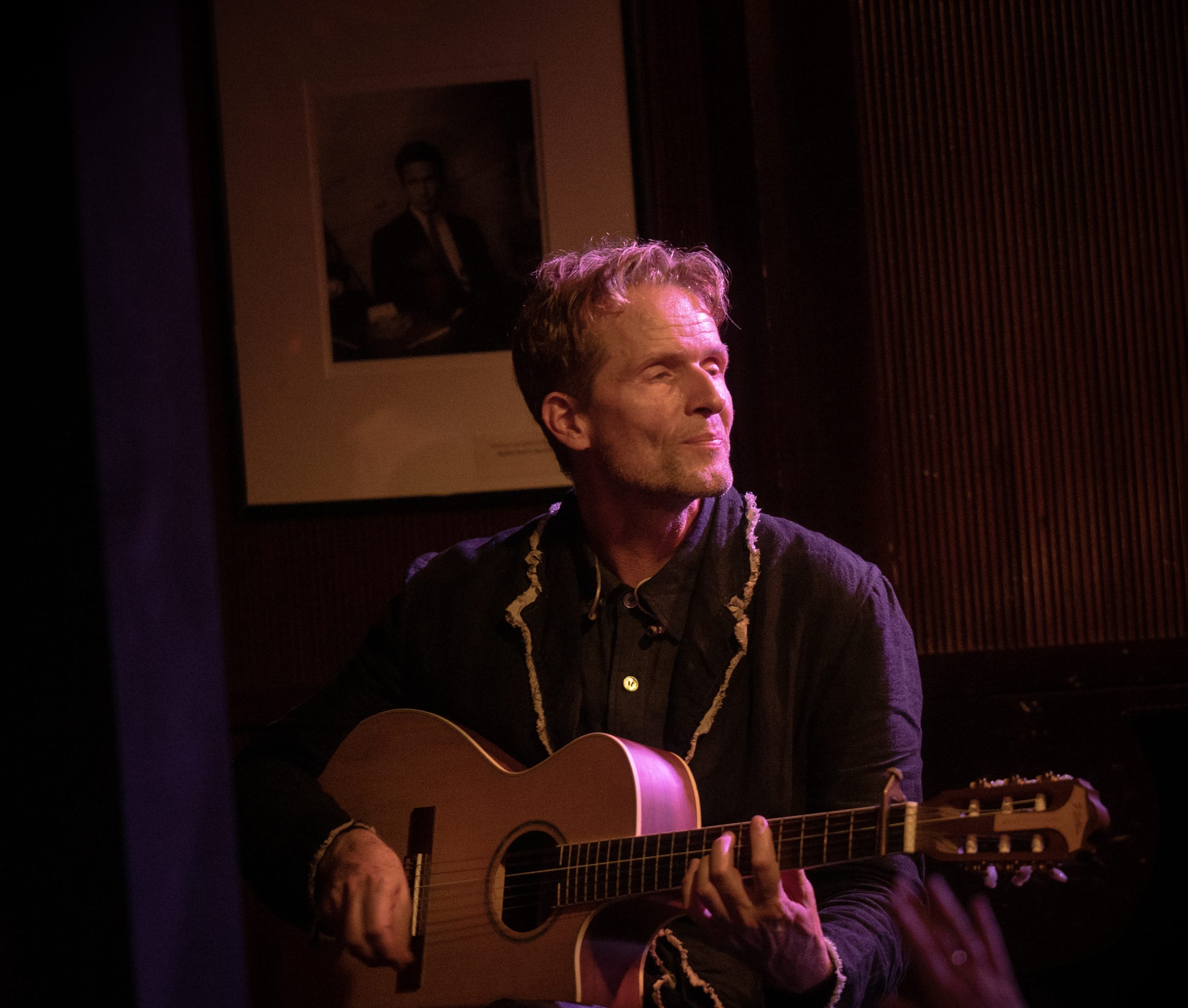 Toby Gad holding an acoustic guitar at Ronnie Scott’s